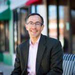 Ed Lazere sits on a bench