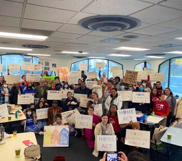 Housing advocates hold signs for the HOME Act